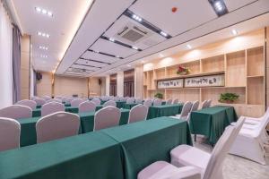 a conference room with green tables and white chairs at Lavande Hotel Ji'nan Railway Station Long Distance Bus Terminal in Jinan