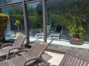 Jutta Deluxe Apartment #325 في باد رايشنهال: كرسيان خشبيان يجلسان على شرفة مغطاة بشبك