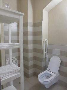 a bathroom with a white toilet and striped walls at Villa Laura in Cocconi
