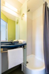 La salle de bains est pourvue d'un lavabo et d'une douche. dans l'établissement ibis budget Châtellerault Nord, à Châtellerault