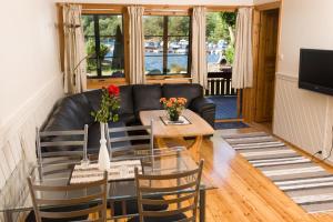 a living room with a black leather couch and a table at Mones Feriesenter in Mandal
