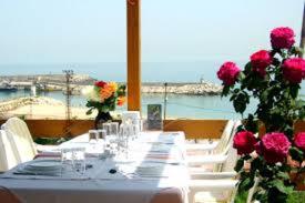 a long table with pink flowers and a view of the ocean at Gizlibahce Hotel in Karaburun