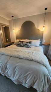 a large white bed in a bedroom with two pillows at Critchley Hackle - Deluxe garden units in Dullstroom
