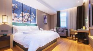 a bedroom with a large bed with a painting on the wall at Jinjiang Inn Wuhan Linjiaohu Wanda Branch in Wuhan +214 photos