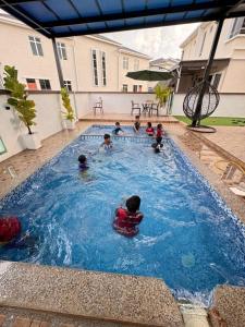 a group of children playing in a swimming pool at Hakeem Homestay in Pokok Sena