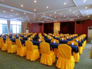 a conference room with blue tables and yellow chairs at GreenTree Inn Suzhou Guanqian Yangyuxiang Metro Station Business Hotel in Suzhou