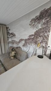 a bedroom with a couch and a painting on the wall at Critchley Hackle - Deluxe garden units in Dullstroom
