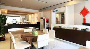 a dining room with a table and white chairs at JinJiang Inn Nanjing The Confucius Temple Zhonghuamen Metro Station in Nanjing