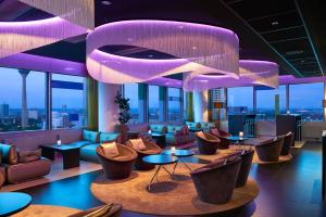 a lobby with couches and tables and purple lighting at INNSiDE by Meliá Düsseldorf Hafen in Düsseldorf