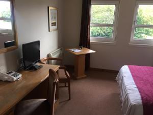 Zimmer mit einem Schreibtisch, einem Computer und einem Bett in der Unterkunft The Gilvenbank Hotel in Glenrothes