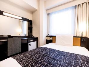 APA Hotel Higashi Umeda Minami Morimachi Ekimae في أوساكا: غرفة فندق بها سرير ونافذة