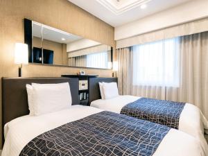 APA Hotel Higashi Umeda Minami Morimachi Ekimae في أوساكا: غرفة فندقية بسريرين وتلفزيون