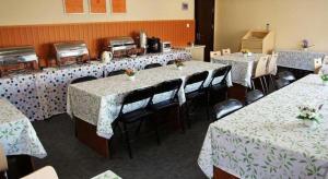 a row of tables and chairs in a room at 7 Days Inn Qingdao Haier Zone Ditie Tower Jiushui West Road in Laoshan
