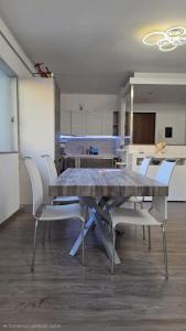 a dining room with a table and white chairs at GS Valtellina in Morbegno