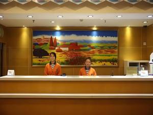 two women are standing behind a counter in a building at 7 Days Inn Nanjing Xinjiekou Changfu Street Metro Station in Nanjing