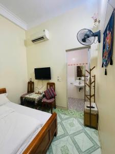a bedroom with a bed and a tv and a chair at Lien Huong Hostel in Ha Giang