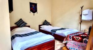 a bedroom with two beds and a clock on the wall at Lien Huong Hostel in Ha Giang