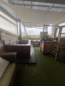 - un salon avec une baignoire et un canapé dans l'établissement My Dream Wedding Apartments, à Nathon Bay