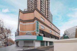 a building on a street with tall buildings at GreenTree Inn Nanjing Confucius Temple Sanshan Street Subway Station Express Hotel in Nanjing