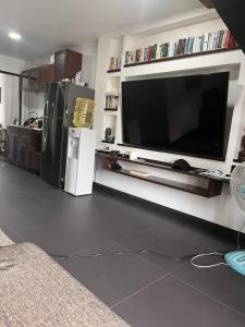 un salon avec une grande télévision à écran plat sur un mur dans l'établissement My Dream Wedding Apartments, à Nathon Bay