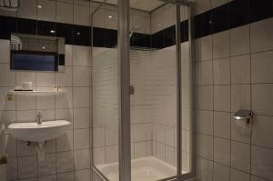 uma casa de banho com um chuveiro e um lavatório. em Hotel Royal Zelzate em Zelzate