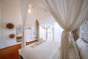 a bedroom with a canopy bed with towels on it at 4BR Villa for Families - 5 Min to Thomas Beach in Ungasan +51 photos