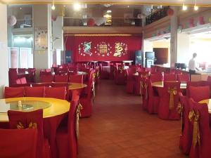 a dining room with red chairs and tables and a chinese wall at Qingdao Donghai Hotel in Qingdao +101 photos