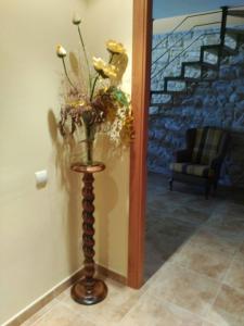 a vase of flowers in a hallway with a chair at Cal Farre in Arbeca