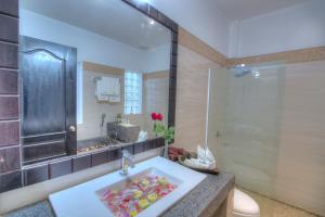 a bathroom with a sink and a shower at Kravan Siem Reap Boutique Villa in Phumĭ Kruŏs