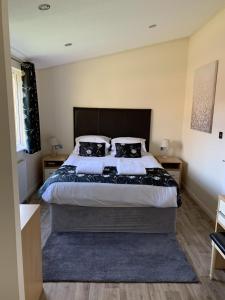 a bedroom with a large bed with two black pillows at Field View 2 bed - Hazel in Horham