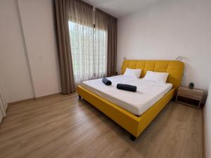 a bedroom with a bed with a yellow headboard and a window at Modern 3 bedroom villa with pool in Paphos City