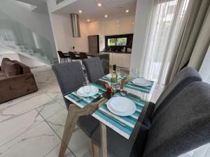 a dining table and chairs in a living room at Modern 3 bedroom villa with pool in Paphos City