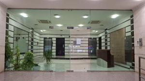 Una gran pared de vidrio en un edificio con plantas en macetas. en Fatima Hostel, en Mascate