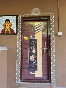a door with a painting on the side of a building at Jungle Tree Hampi in Hampi