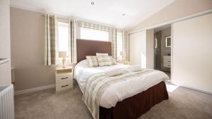 una camera da letto con un letto grande e una finestra di Primrose 2 bed - Violet a Horham