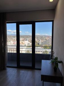 a room with a large window with a view of a city at Ameri Plaza Lilu Home apartment in Tbilisi City