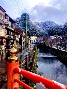 a river in the middle of a town with mountains at BookStore iChi in Toyooka