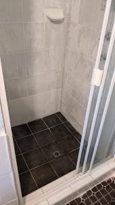 Una ducha con puerta de cristal y suelo de baldosas en Bidwill Garden, en Bidwill