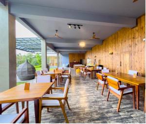 Mazarine Surf Suites- Hiriketiya في Nilwella: مطعم بطاولات وكراسي خشبية في الغرفة