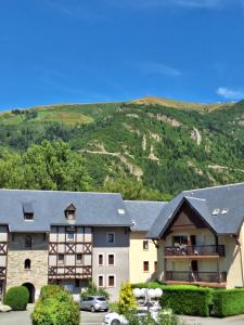 a large building with a mountain in the background at Bel appartement Résidence Hameau du Parc Saint Lary Vignec in Vignec