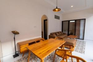 a living room with a wooden table and chairs at Maharani Villa & Guesthouse Uluwatu in Uluwatu
