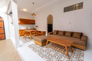 a living room with a couch and a table at Maharani Villa & Guesthouse Uluwatu in Uluwatu
