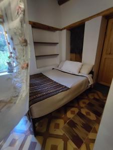 ein kleines Bett in einem kleinen Zimmer mit einem Fenster in der Unterkunft Loft acogedor in Ollantaytambo