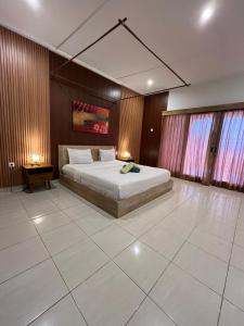 a bedroom with a large bed in a room at Azona Greens Uluwatu in Uluwatu