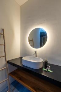 a bathroom with a sink and a mirror on a counter at Maharani Villa & Guesthouse Uluwatu in Uluwatu