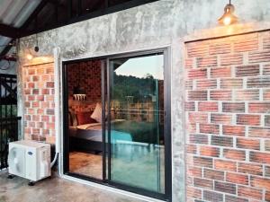a brick wall with a large sliding glass door at Baan Malee Villa in Ko Lanta