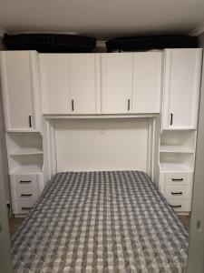 コクセッドにあるStudio Vriedom aan zeeの空のクローゼット(白いキャビネット、ベッド付)