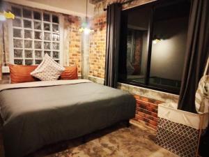 a bedroom with a bed and a brick wall at Baan Malee Villa in Ko Lanta +14 photos