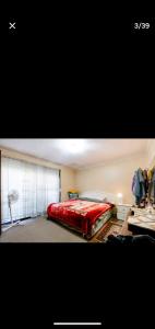 a bedroom with a red bed and a window at Bidwill Garden in Bidwill