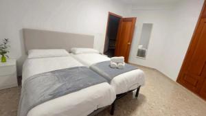 una camera con due letti e un orsacchiotto seduto sopra di Villa Bobal a Requena